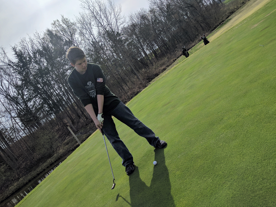 Sophomore Ethan Schomberg attempts a putt during practice. The golf team had their first match in Higginsville on March 21.