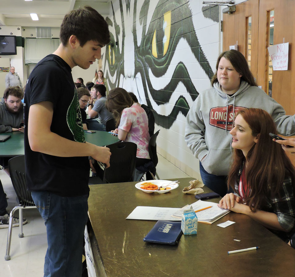 Junior Destiny Lee sells prom tickets to senior Tommy Reffett. This year's prom theme is a masquerade inspired by
