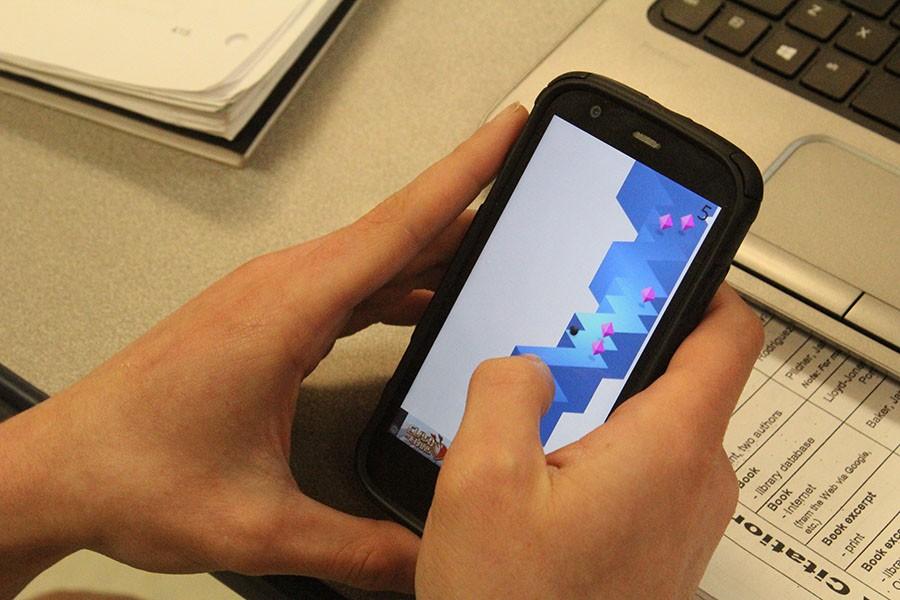 A student plays a game on their phone. Gaming is a large part of students lives.