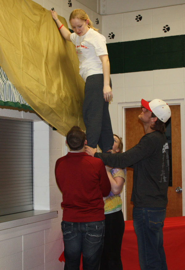 Seniors Jake Freeman, Brooklyn Spencer, and Kyle Goodsell lift Melissa Pierce while setting up for the dance. The journalism staff prepared for weeks and set up for six and a half hours the night before. 