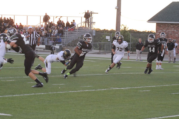 Senior Devon Parish carries the ball to make a touchdown during the Homecoming game. The boys lost against Versailles 14-45. 