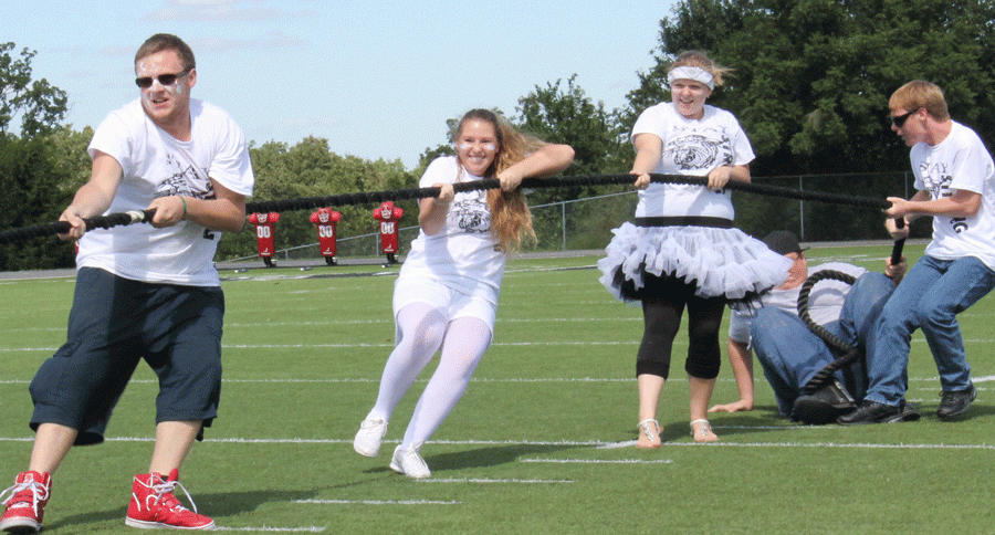 Juniors Damian Woods, Johna Newman, and Haleigh Kennedy play tug-of-war in the homecoming games. Students wore their Warsaw strong shirts during homecoming to show their class pride. 