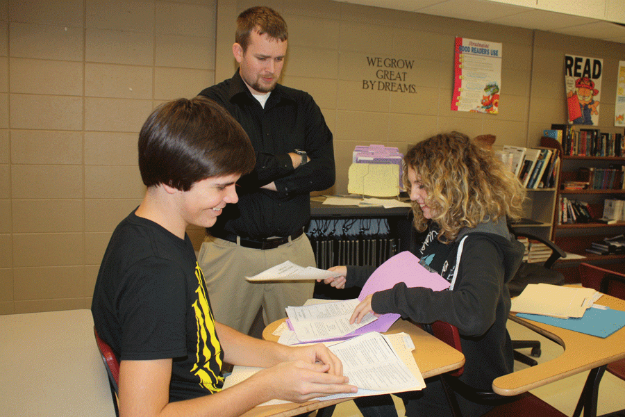 Speech coach Nathan Hopkins helps speech students freshman Mason Knox and Alexia Young choose their next piece. Hopkins has been a speech coach for two years. 