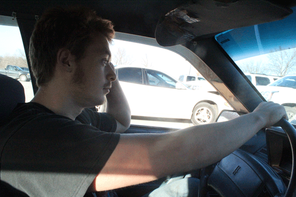 Senior Derek Wright rests his hands on the wheel. Wright has spent over $1000 on his vehicle.