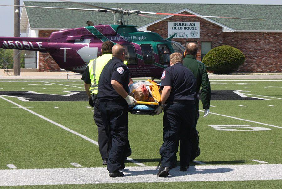 Senior Madison Lane gets carried to the helicopter to be lifeflighted. Docudrama was held as a practice run for emergency personnel. 