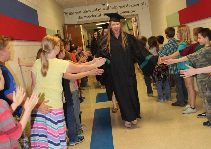 Senior Maddie McMillin celebrates with elementary students at South Elementary on May 13.