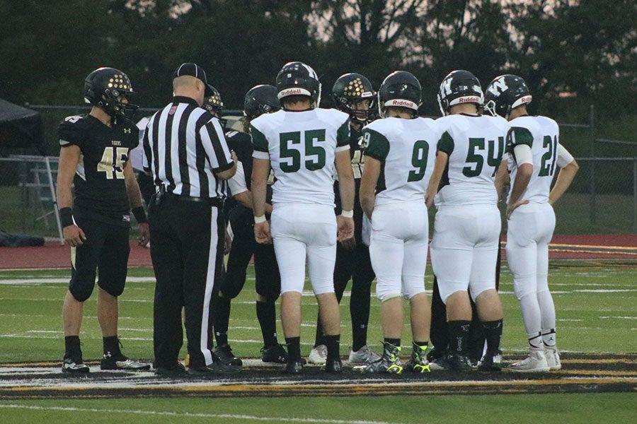 Senior captains Dakota Bilderback, Michael Pierce, Aaron Reno and Trenton Simons meet with the Versailles captains for the coin toss. Head coach Paul Thomas said that the seniors had a great attitude and always taught the underclassmen right from wrong. 