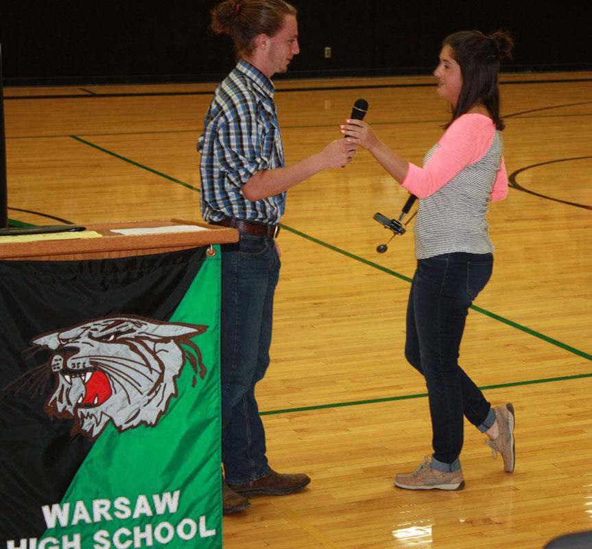 Student body president Noah Long hands the microphone over to senior class president Erica Flores. Flores gave a speech about finishing the school year out strong.
