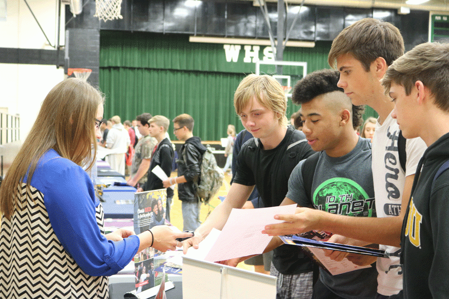 UCM representative Brandy Potter scans the bar codes of sophomores  Zach Riggs, Kieon Davis, Mason Knox, and Riley Bagley. Freshman and sophomores had to sign up to attend  the college fair while juniors and seniors were invited.
