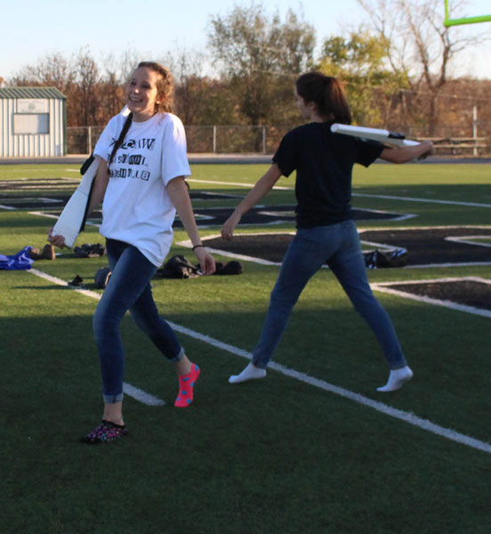 Sophomores Rylee Pals and Autumn Rhea practice switching sides for indoor color guard. This is the first year indoor color guard will continue into the winter.