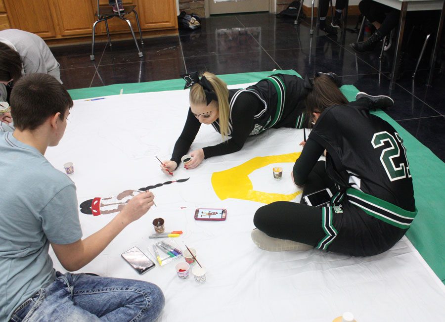 Seniors Nathan Stutes,
Makayla Mais, and Rebecca Letcher
paint the senior banner for the
Courtwarming assembly. Each class
worked on banners during the school
day and they were judged during the
assembly.