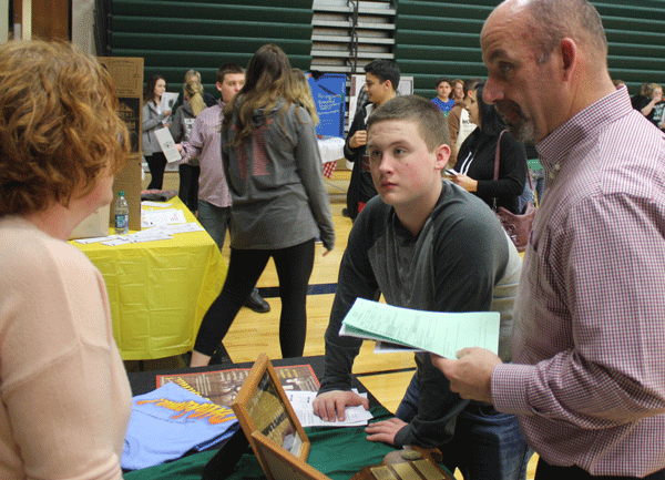 Eighth grader Grady Miller and parent Jim Miller talk to choir director Deanna Schockmann during eighth grade parent night. Eighth grade parent night was held on Thursday, March 2. 