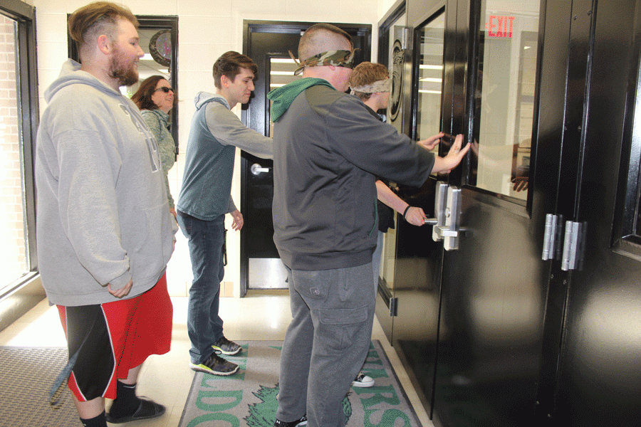 Seniors Chris Bozarth and Tommy Reffett guide seniors Johnathan Kirmse and Garrett Smith  in opening the doors to the school. Bozarth and Reffett guided Kirmse and Smith back to their psychology classroom.