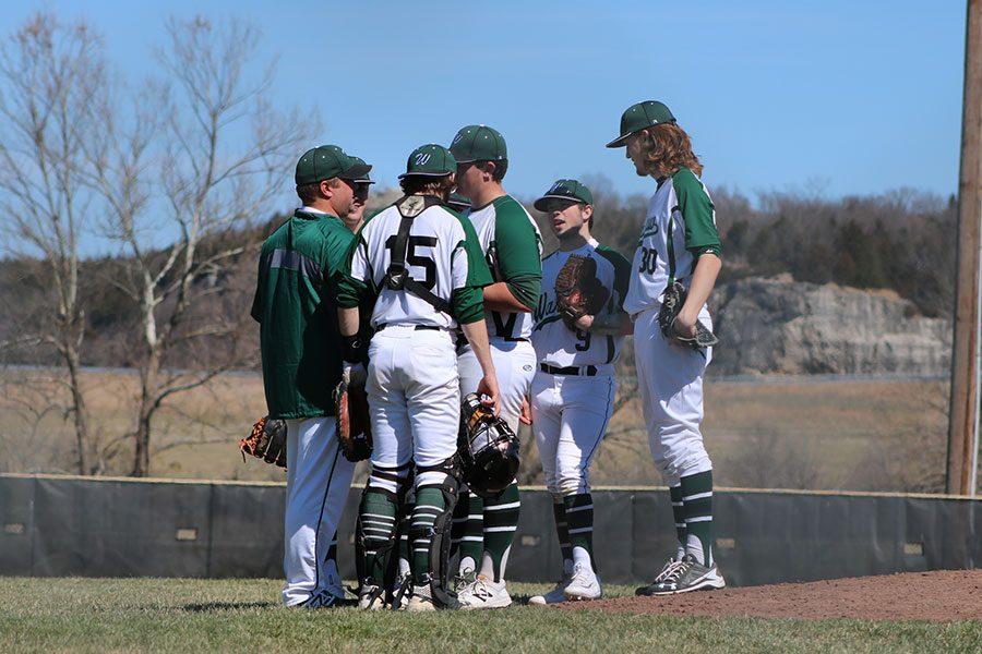 Coach Jerome Bagley talks to players including seniors catcher Hunter Bagley, pitcher Austin Gardner, second baseman Corey Callahan and junior first baseman Cash Miller during Saturday’s game against Holden. This is Jerome’s first year coaching for the school. 