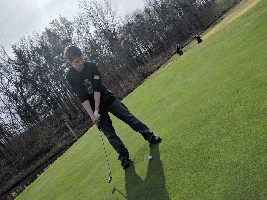 Sophomore+Ethan+Schomberg+attempts+a+putt+during+practice.+The+golf+team+had+their+first+match+in+Higginsville+on+March+21.+