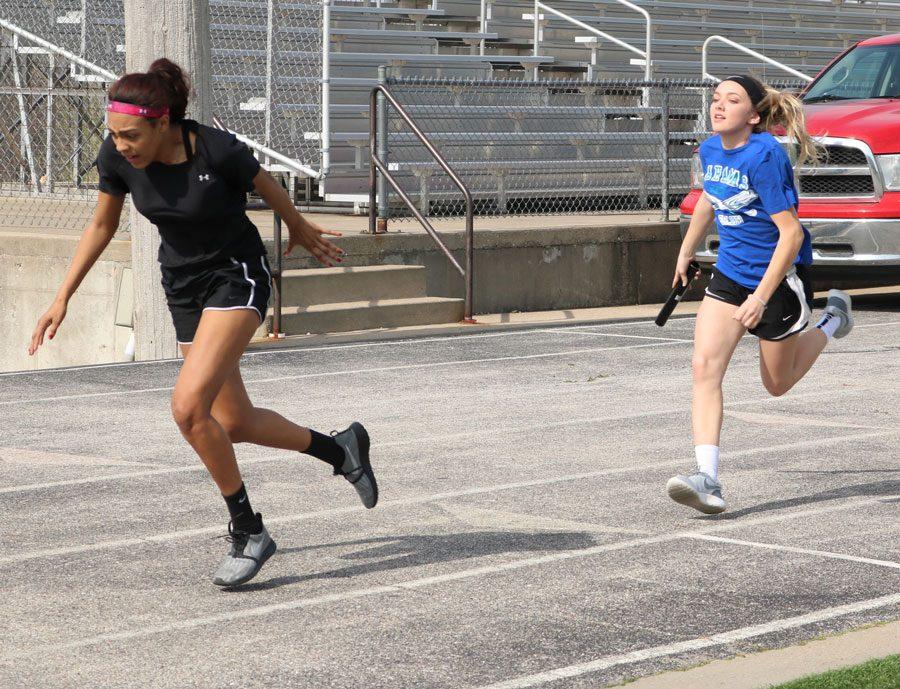 Freshman Rayni Simons passes the baton to freshman Ariaunna Johnson. The track team started practice during the first week of March.