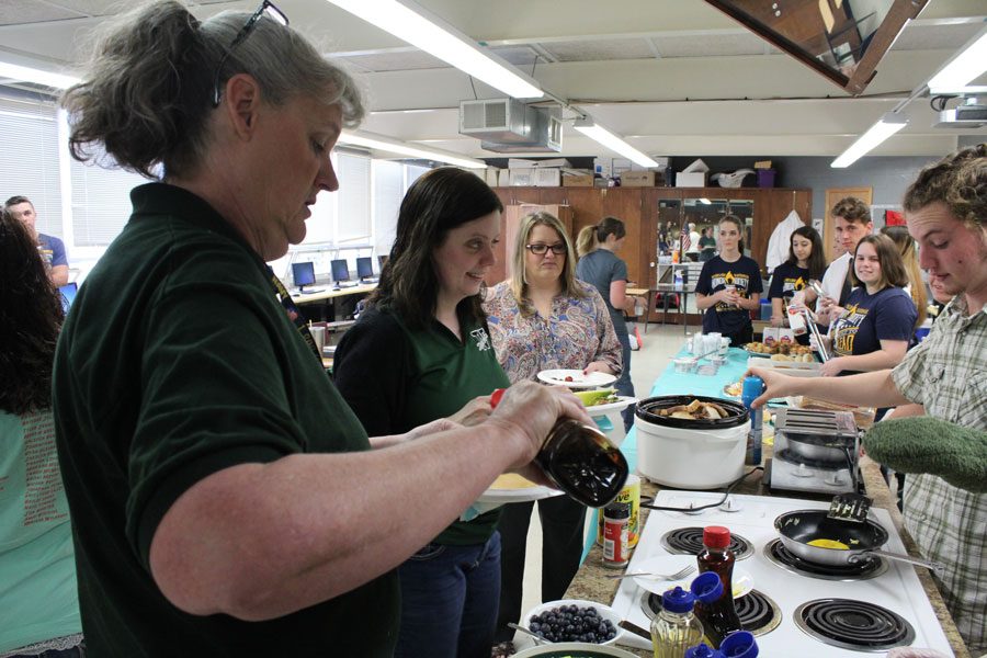 Substitute teacher Peggy Switzner and middle school English Maria Webster make their plates at the breakfast on Thursday, April 13. The students in the National Honor Society organized the breakfast to show appreciation for teachers and other staff.