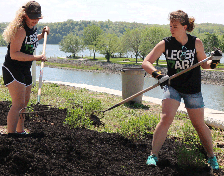 Seniors Samantha Thompson and Johna Newman rake mulch at Drake Harbor. The seniors went to the harbor, the bike trails, and the golf course to clean up trash and do landscaping work.