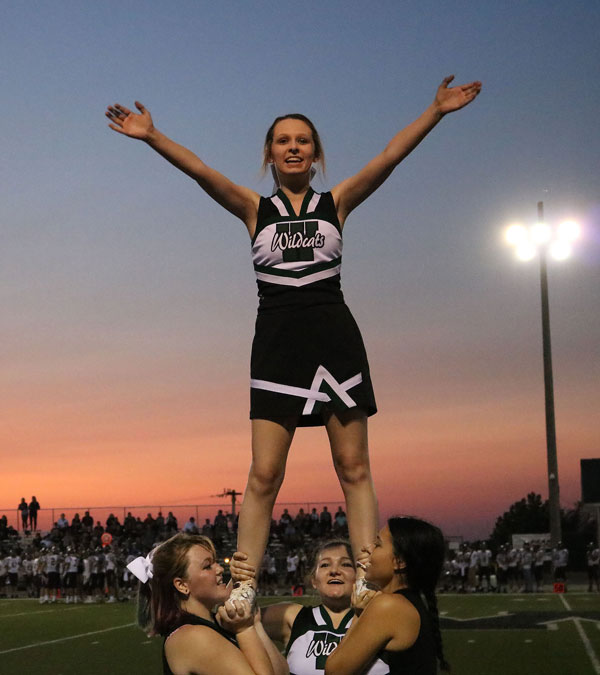 Senior Madi Rozzel and juniors Helena Givens and Chloe Lux lift sophomore Brooklyn Duncan during a cheer performance. This was Duncan’s first year on the high school cheer squad. 