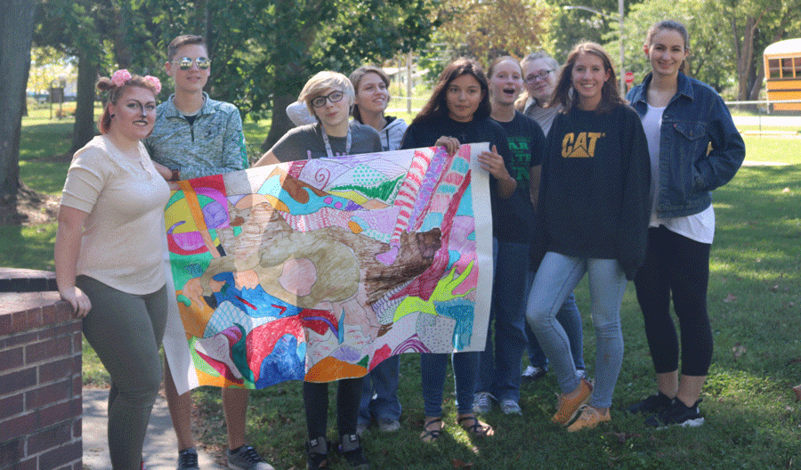 Senior Madi Rozzel, senior Colter Hetherington, senior Molly Baumhoff, freshman Lacey Andrews, junior Kinsten Cunningham, sophomore, Kathryn Ricky, somophore Jessica Dwyer, junior Abby Foster and junior Madilyn Gardner displaying their group project they all worked on  together. 