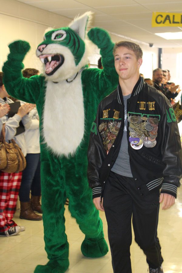 Senior Dallas Larsen walking the main hall through all of the Warsaw high school supporters. Larsen is having his state walk through the hall with the wildcat.