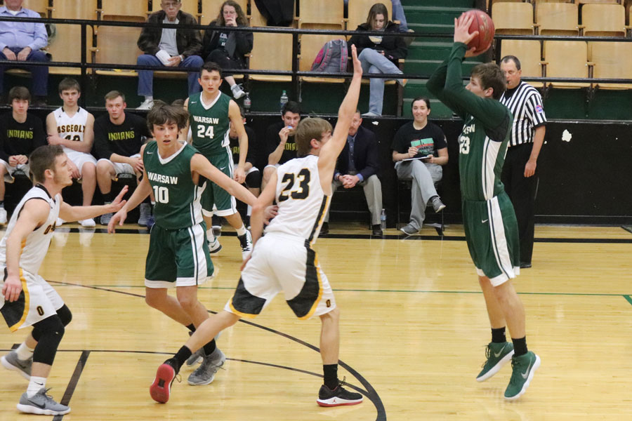 Junior Logan Davis and senior Tyler Simons block while junior Matt Luebbert takes a shot. Luebbert went on to play Osceola again in the Skyline tournament where he hit his 1,000 career point.