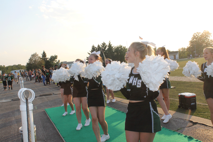Juniors Alexus Brown and Andrea Merritt cheer on the football team during the home game against Midway. The game was held Aug. 24.