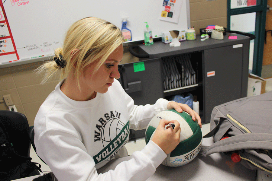 Junior Rheanna Coke writes a quote on the leadership ball. Coke was chosen to represent the ball due to her outstanding role on the court and her inclination to charge.