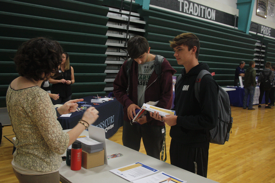 Seniors Joey Mace and Riley Bagley collect pamphlets about a community college at the school college fair. The college fair took place from 12-3:30 on Sept. 28.