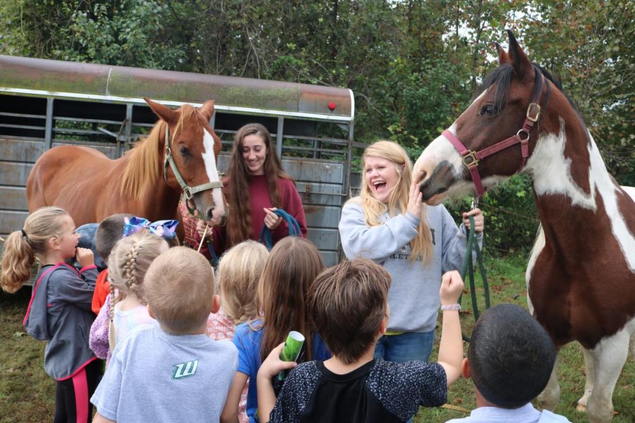 Juniors Savannah Neth and Allison Pool show off their horses to elementary students at Food For America on Oct 5. The two teamed up for a project about draft horses.