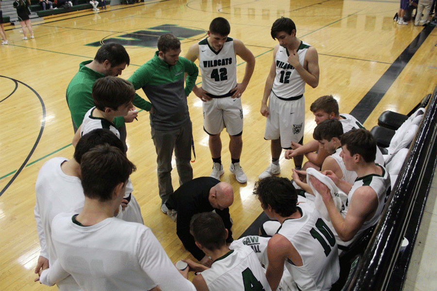 Players on the boys basketball team huddle together to go over plays. Many of the basketball players were recognized for their accomplishments at the winter sports banquet.