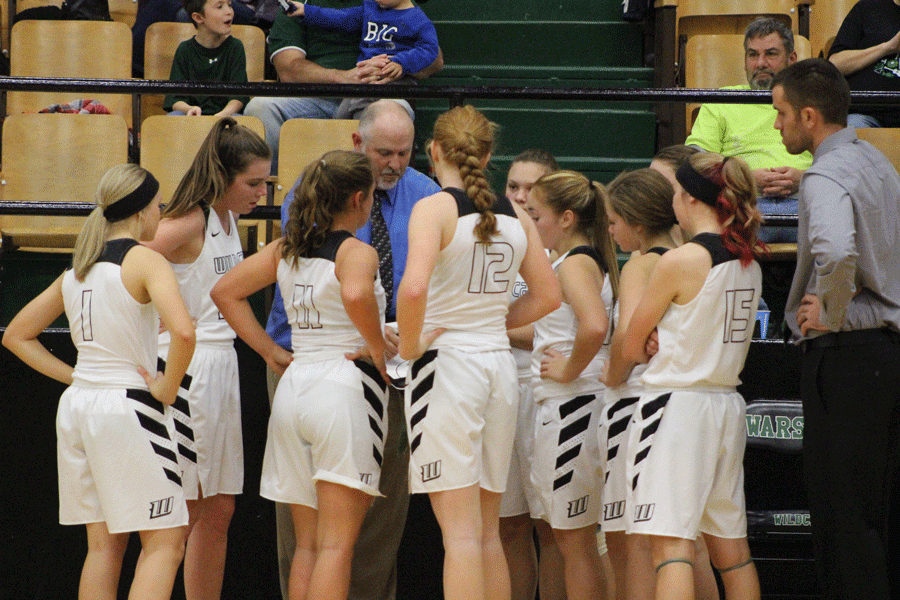 The girls basketball team gathers around for coaching during a timeout.. Many of the people pictured earned their JV letters at the sports banquet.