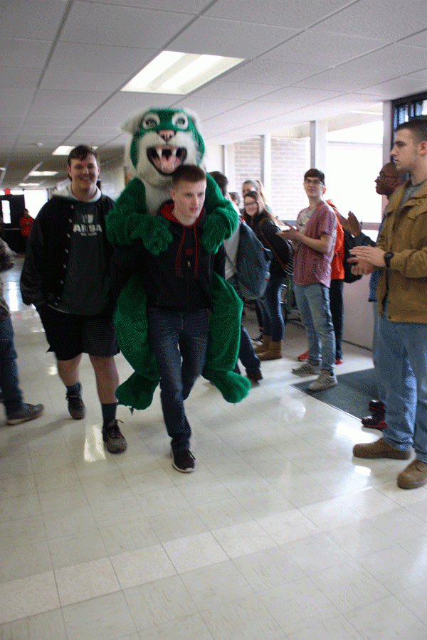 Senior Kolby Estes carries the mascot through the halls as he and sophomore Colby Stephens participate in their state walk. Estes was named “Grappler of the Year” and Stephens earned his varsity letter in wrestling.