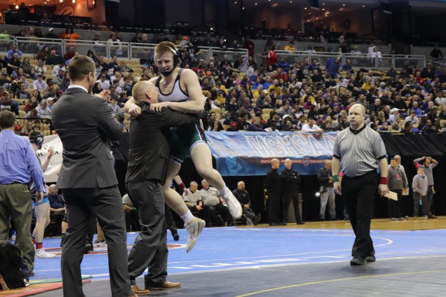 Senior Kolby Estes jumps into the arms of his father and coach after being declared the state champion in the class 152 weight class. Estes won second in state both his sophomore and junior years.  