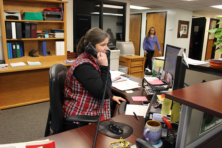 Administrative assistant Cindy Murrell helps a caller who contacted the high school office. “I had never been a ‘secretary’ before accepting this position,” Murrell said, “but I had office management, public relations experience, planning and organizational skills from my previous jobs. ” 