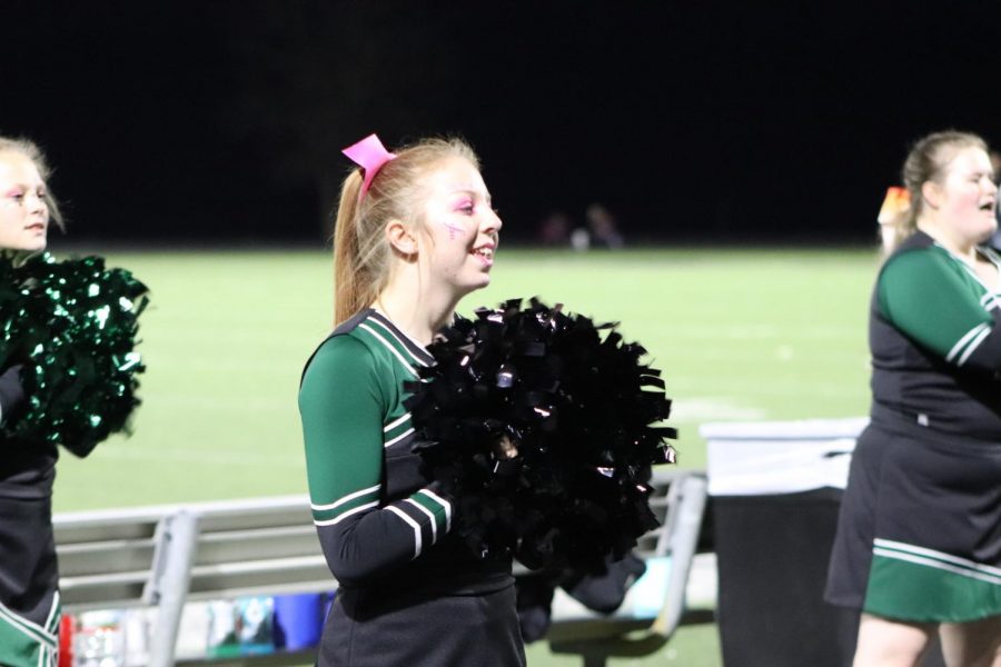 Junior Kaylee Lawson shouts a cheer for a home football game against Skyline for there pink out theme