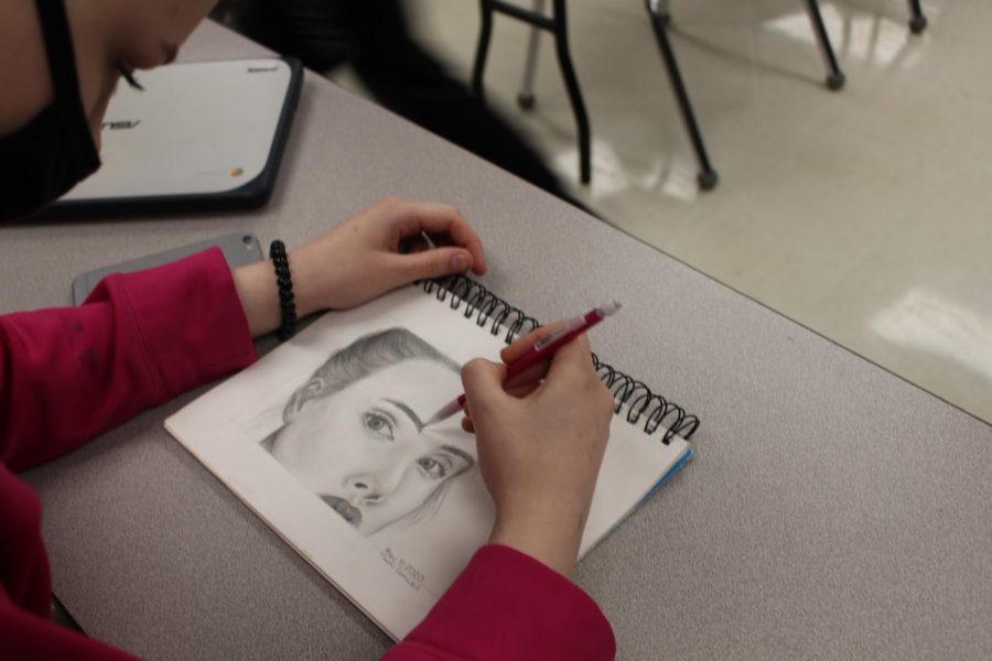 Freshman Tiami Conwell sketches a realistic graphite portrait during class. She is heavily supported by her mom to continue with art, even when things are difficult.