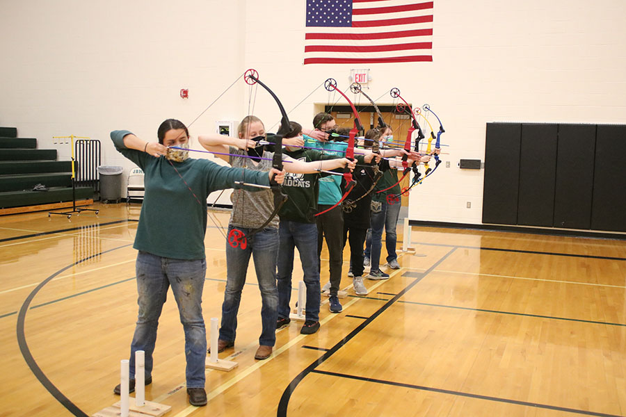 Members of the high school archery team senior Emmaleigh Kowal, sophomore Samantha Pearman, freshman Elliot Kowal, sophomore Logan Schockmann, junior Ryellie Umlauf, junior Alyssa Alcantara and freshman Alyson Alcantara stand at the 10-meter line as they prepare to fire at their targets. The high school team qualified for the state bullseye tournament with their combined score of 3,151.