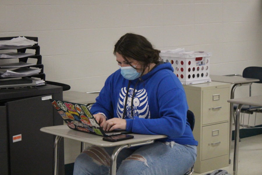 Junior Ashley Spry wears masks while working on school work in Amy Spunaugles math class. 