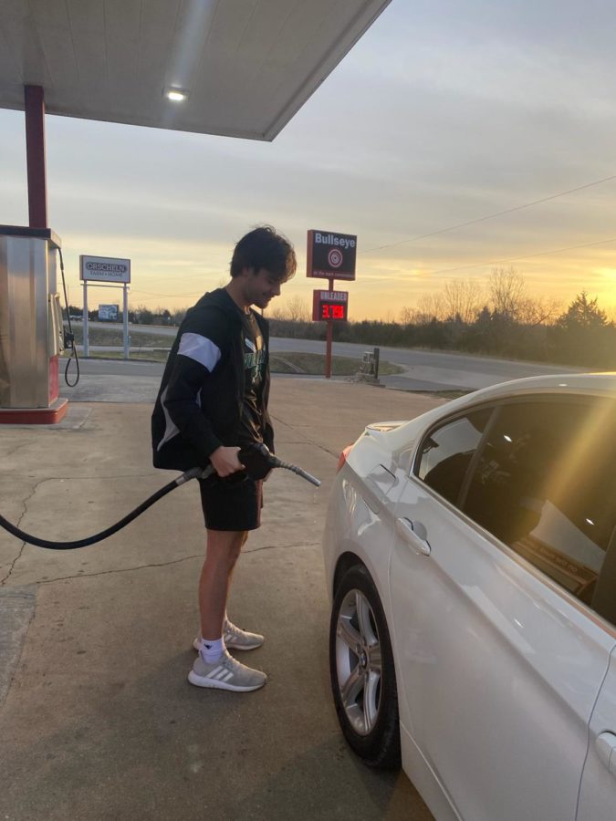 Freshman Joshua Bunch pumps gas for Sophomore Ciara Kleihauer on Tuesday morning. Students are feeling stressed financially by increased gas prices.