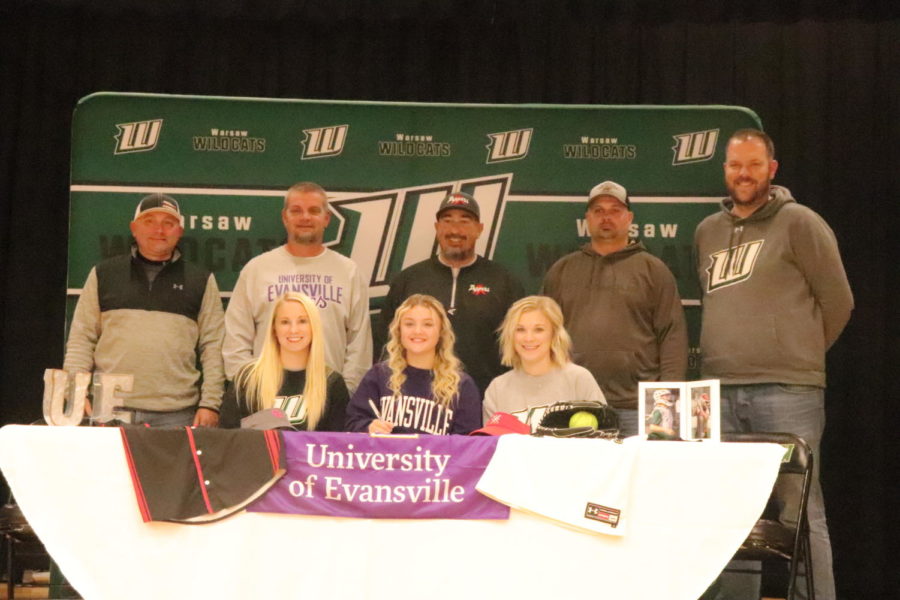 Senior Taylor Howe (middle bottom row) signs onto Evansville University Indiana with coaches and family by her side. 