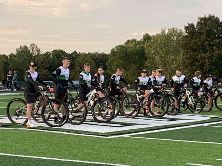 Mountain biking team lined up to be introduced at a home football game.