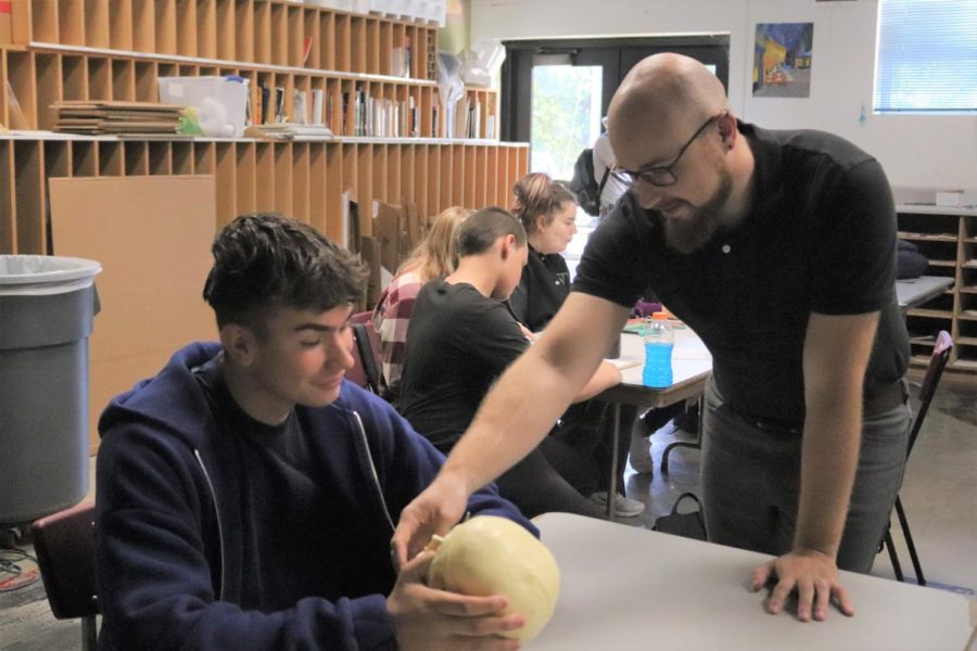 Art teacher Derek Norton discusses his skull sculpture with foreign exchange student Paul Hinz. Norton and his family are hosting Hinz from a small town in Germany, Wandlitz.
