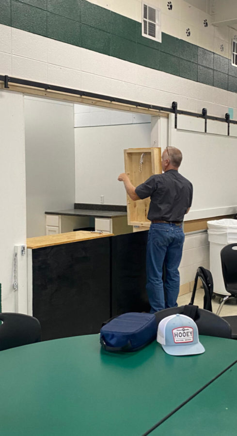 Maintenance director Tim snider installs a counter top in the new concession stand. The new space was ready before the start of basketball season.