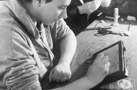 Senior Rian Dotson works on a project in his art class. 