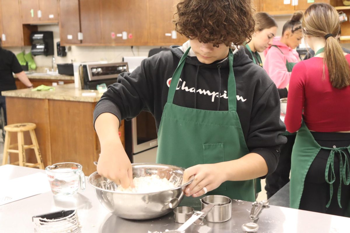 Freshmen Jordan Brown works on his cupcake batter. The foods classes were having a cupcake competition. 
