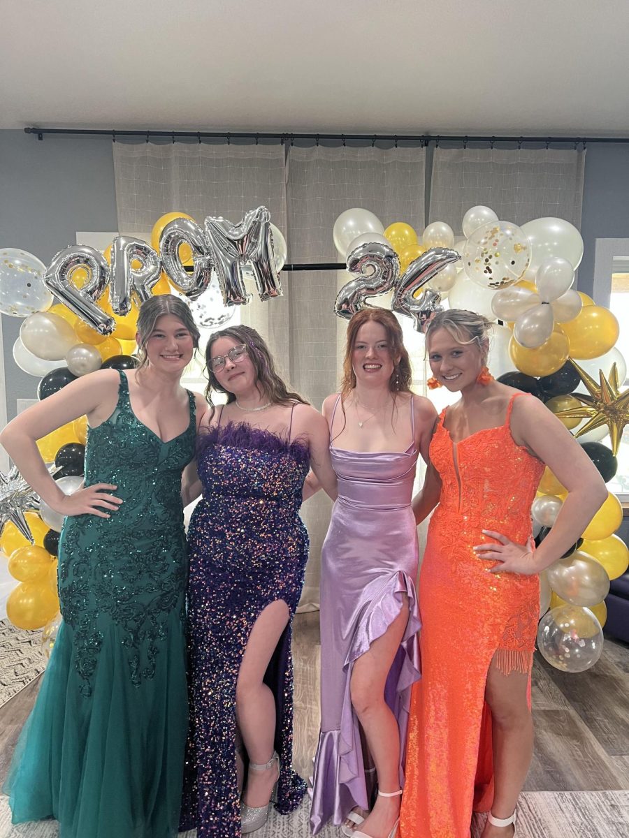 Seniors Josephine Kelsey, Abbi Flinn, Hunter Collins, and Laney Arnett smile and get together before prom. “I enjoyed getting ready with my best friends for the last time,” Arnett said.