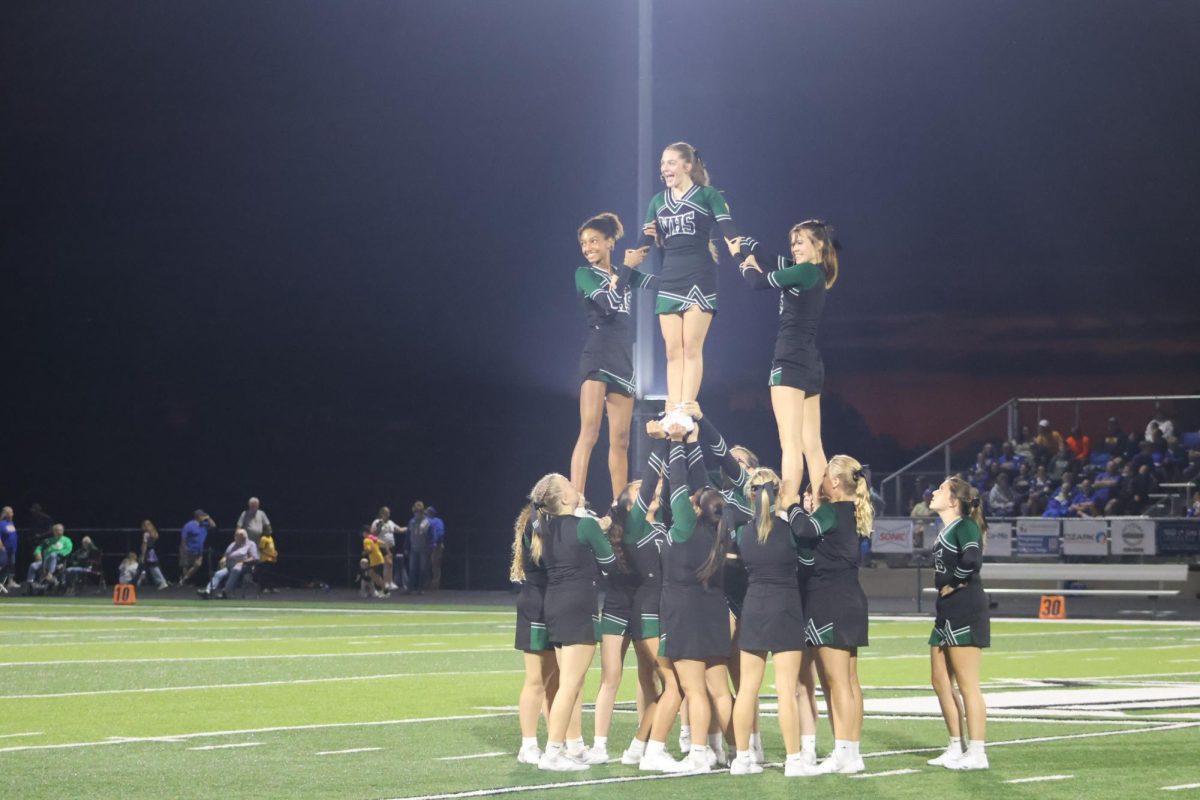 Stunt teams lift freshman Addison Hill, and sophomore's Izzy Schierholz and Elizabeth Phillips to form a pyramid at half time of their first home game performance.