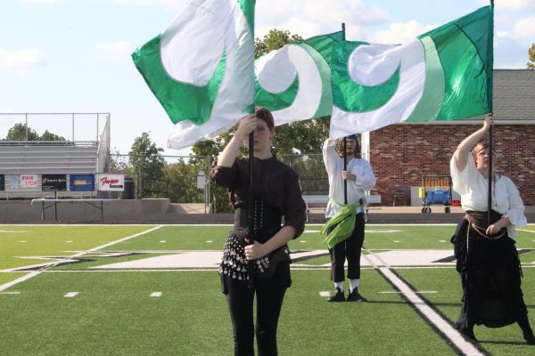 Freshman Riley Nevius, junior Dillan Ellison, and senior Haylie Allen perform their flag routine. They performed their routine at the OHC clinic on Sept. 14.