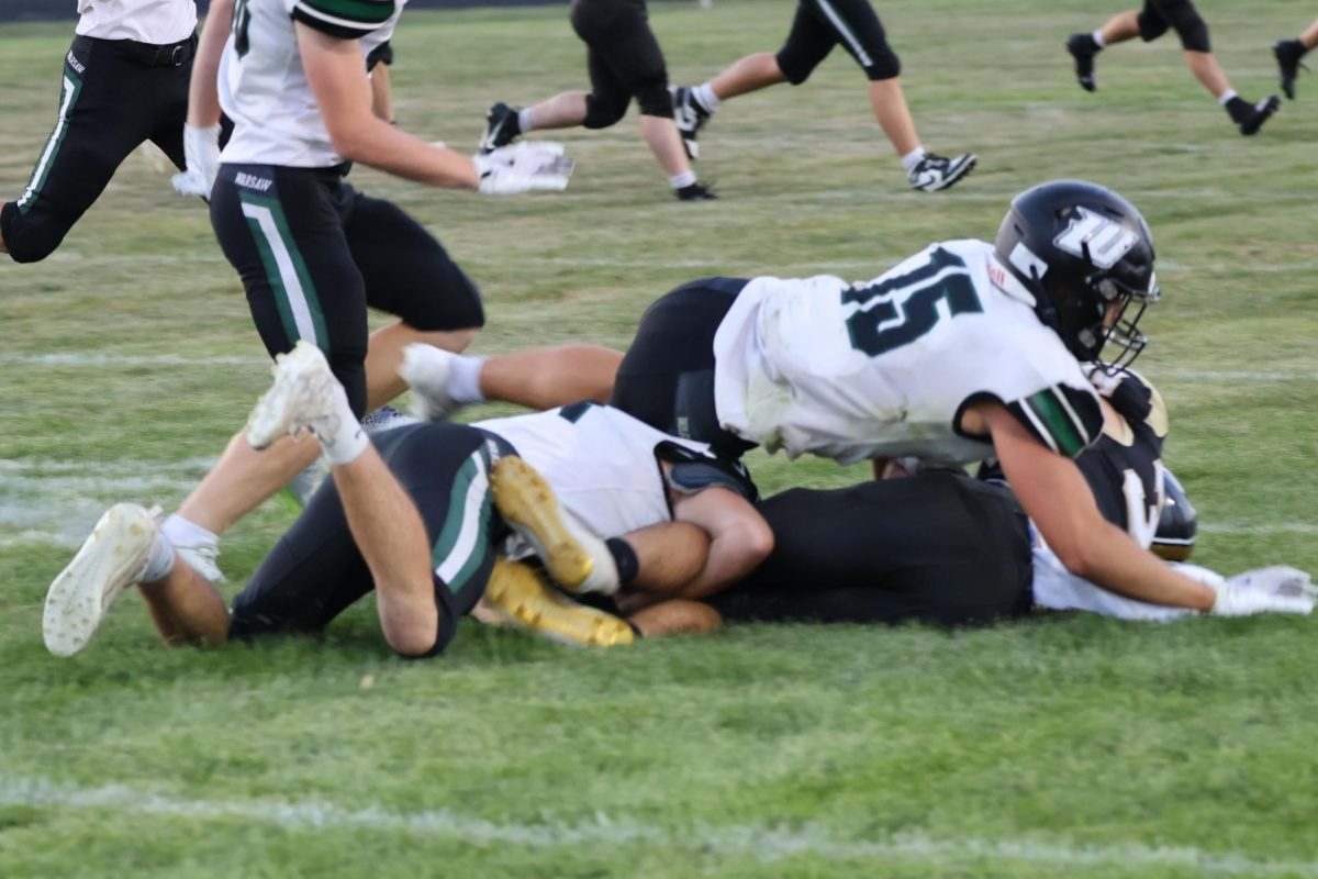 Seniors Drake Murrell and Michael Garrett use teamwork to tackle the opponent. They are two of twelve seniors on the team.